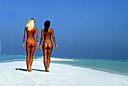 Jeunes femmes en tenue d'Eve, de dos sur une plage de corail